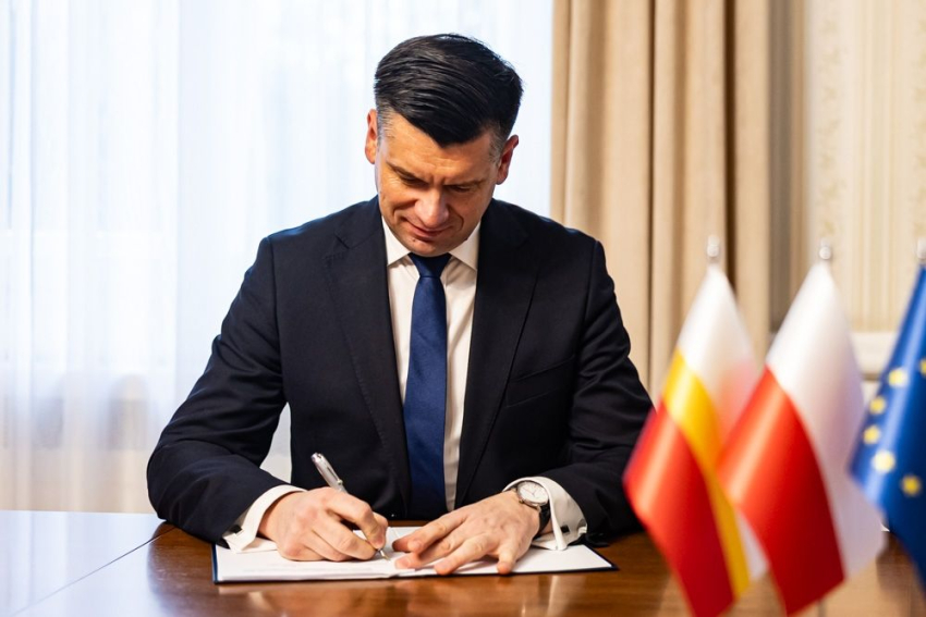Marszałek Łukasz Smółka podpisuje umowę.
