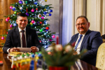 Marszałek Małopolski siedzi z uczestnikiem spotkania przy stole.